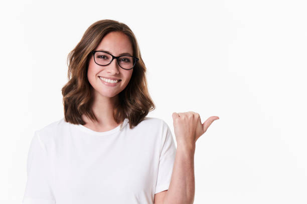 Pointing glasses girl Pointing glasses girl in white studio, portrait pointing stock pictures, royalty-free photos & images