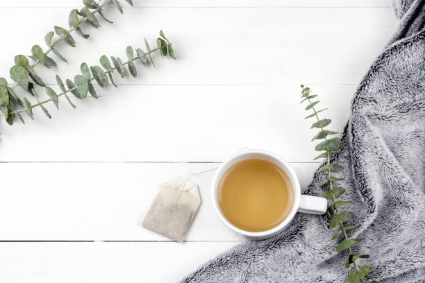istock Morning tea cup with Eucalyptus Silver Dollar plant leaves on white wood panel background 1089640436