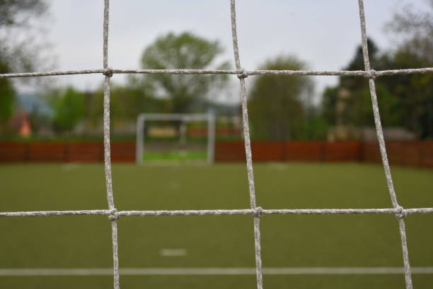 istock Football terrain behind goal net 1089643474