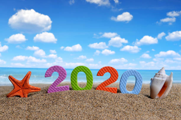 Number 2020 and sea shell with starfish on the beach.