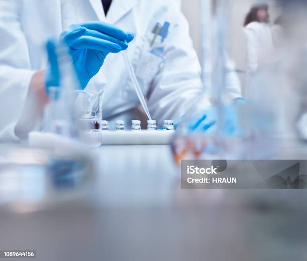 Chemist Filling Vials In Experiment At Laboratory Stock Photo - Download Image Now - Laboratory, Medicine, Healthcare And Medicine
