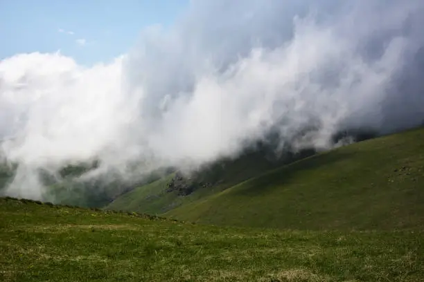 Photo of The green rolling hills under a foggy sky at  mountains Armenia Green meadows in foggy weather. Foggy morning in the mountains.