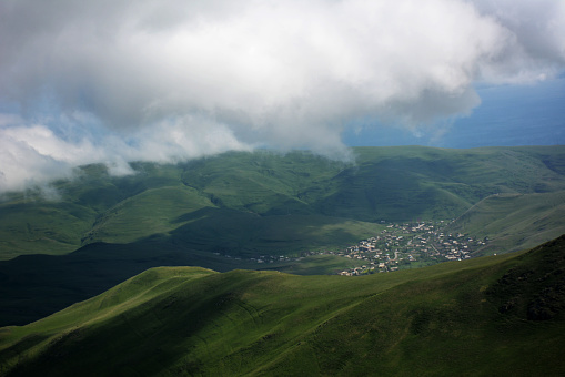 Armenian village Drakhtik at green mountains. Green meadows in foggy weather.