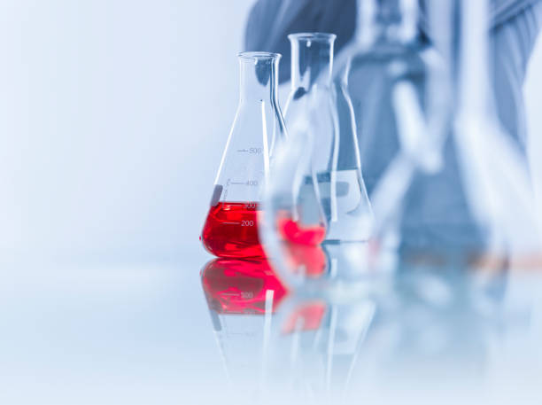Close-up of red solution in conical flasks. Laboratory glassware on table. It is pharmaceutical factory.
