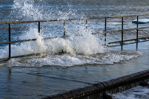 high water is flooding  the quay with spray and splashes, storm in the baltic sea in Travemuende, Germany, copy space