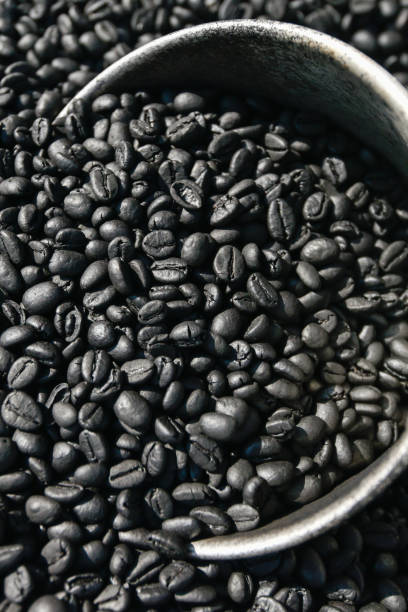istock Freshly roasted aromatic robusta coffee beans in silver scoop on coffee beans ground. Organic coffee. Local product of Krabi, Thailand. Top view, close-up. Selective focus. Low key. Backgrounds, Texture for text. 1089649024