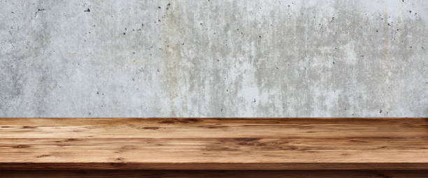 Concrete wall with wooden table Old gray concrete wall with empty rustic wooden table for a background architectural exterior marble stone wall texture stock pictures, royalty-free photos & images