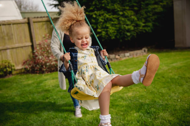 niña primavera divirtiendo - child swing swinging spring fotografías e imágenes de stock