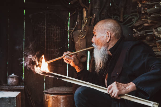 istock Old Senior Chinese man in kitchen smoking pipe 1089666426