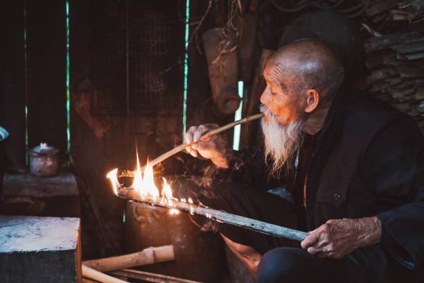 istock Old Senior Chinese man in kitchen smoking pipe 1089666566