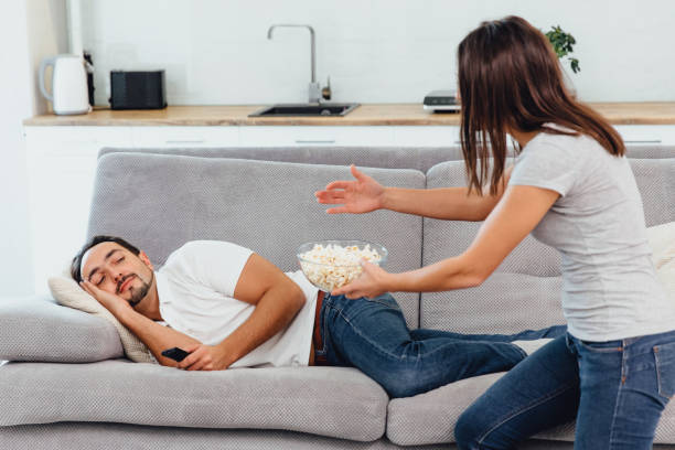 istock Husband sitting on the couch holding popcorn 1089666940