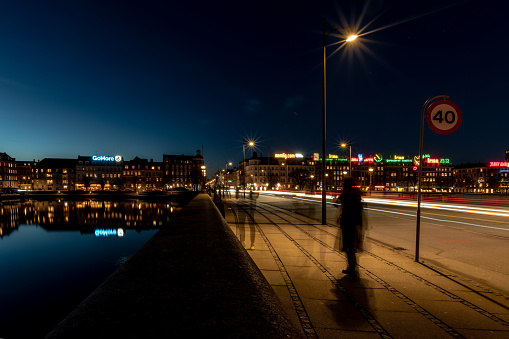 Copenhagen, Denmark. 30th December 2018. People and cars pass on Queen Louise Bridge at night in Copenhagen, Denmark with city behind.