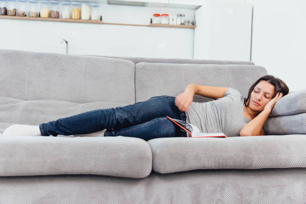 istock A woman reads a book lying on the couch 1089673666
