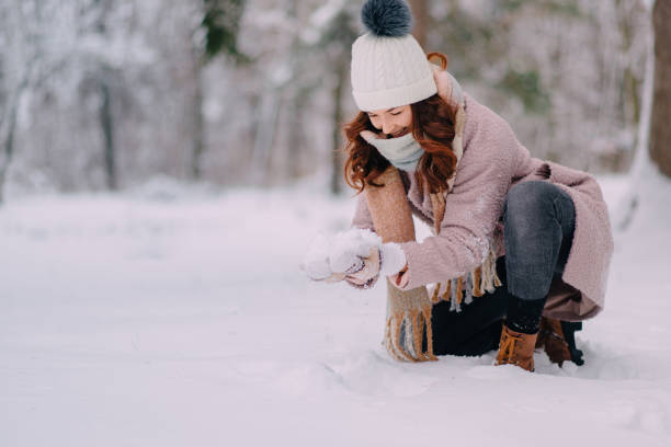istock young woman making snowball hands in park 1089688582
