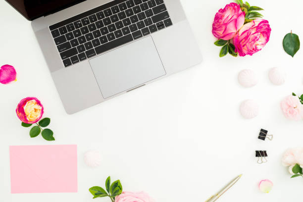istock Frame with laptop, envelope, pen and roses flowers on white background. Flat lay. Top view. Feminine composition 1089689256