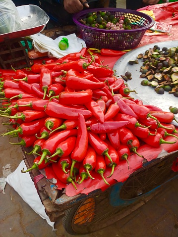 Fresh vegetable produce, including red chillies and tomatoes, displayed at market stall in India.