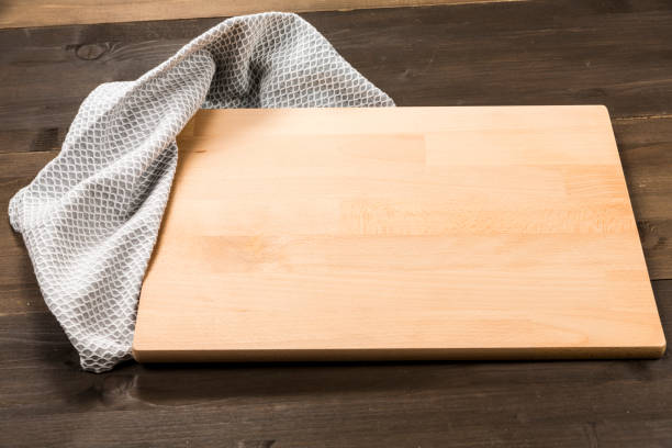 istock Cutting board and checkered tablecloth isolated on wooden background 1089699156