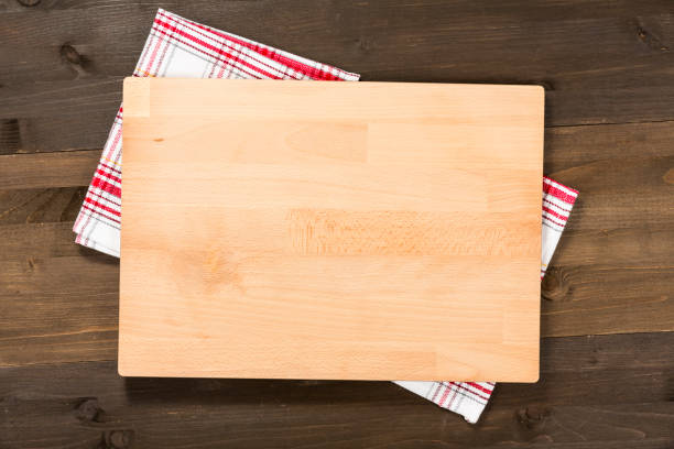 istock Cutting board and checkered tablecloth isolated on wooden background 1089699356