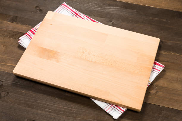 istock Cutting board and checkered tablecloth isolated on wooden background 1089699358