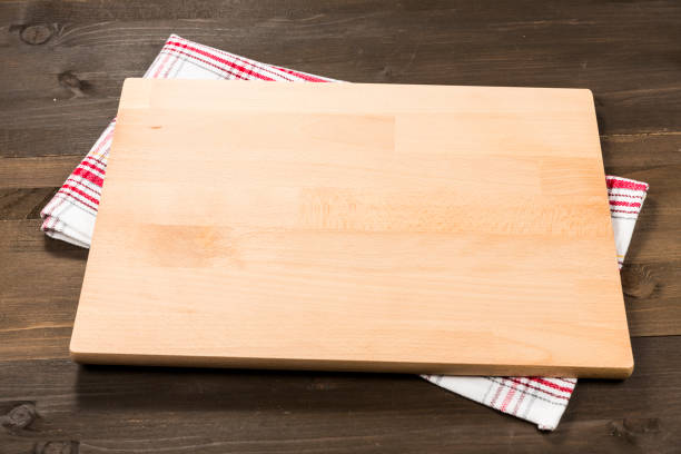istock Cutting board and checkered tablecloth isolated on wooden background 1089699364