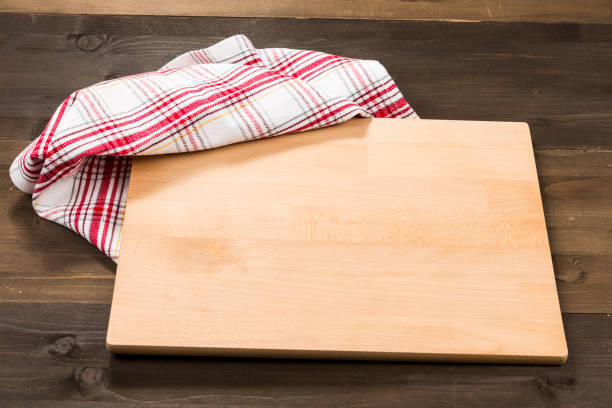 istock Cutting board and checkered tablecloth isolated on wooden background 1089700446