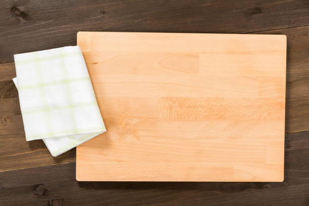 istock Cutting board and checkered tablecloth isolated on wooden background 1089700688