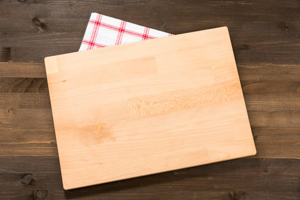 istock Cutting board and checkered tablecloth isolated on wooden background 1089700910