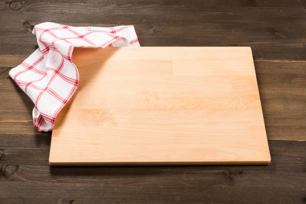 istock Cutting board and checkered tablecloth isolated on wooden background 1089700956