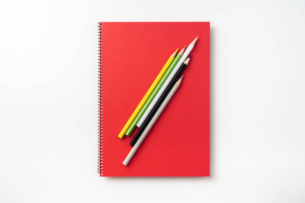 Top view of red spiral notebook, page, pencil Design concept - Top view of  red spiral notebook and lot of pencils isolated on background for mockup handbook book hardcover book red stock pictures, royalty-free photos & images