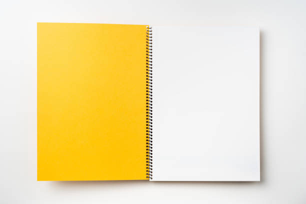 Design concept - Top view yellow spiral notebook with open & flip curl rolled page isolated on background for mockup