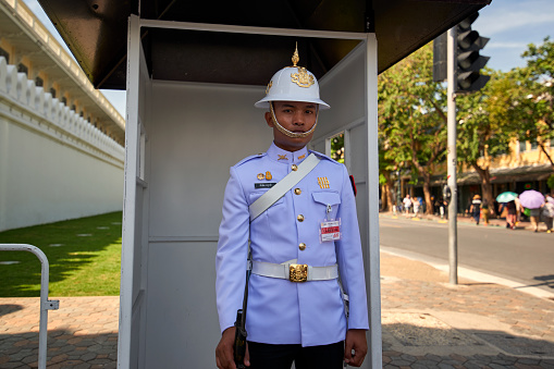 BANGKOK, THAILAND -  22 NOV: Street scene in Bangkok, Thailand on NOV 22, 2016. A Royal Guard stands to attention outside the Grand Palace