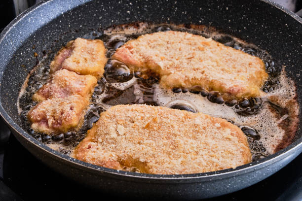 istock Preparing pork schnitzel meat on hot frying pan 1089731426