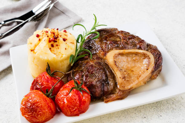 istock Beef steak osso bucco with mashed potatoes and tomatoes on  table. Dish with meat 1089731704