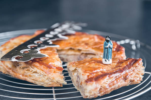 hausgemachte epiphanie könig kuchen blätterteig nahaufnahme mit traditionellen goldenen papierkrone zum feiern im januar - fava bean stock-fotos und bilder