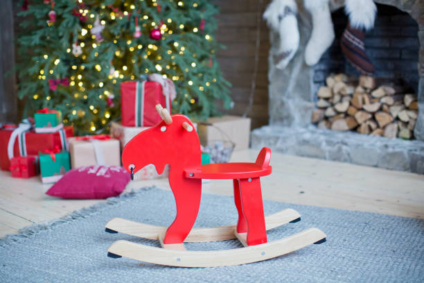 istock red rocking reindeer near Christmas tree 1089747786