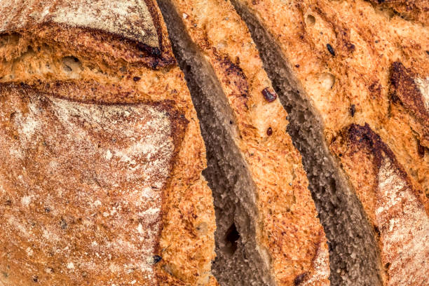 istock Freshly Fireplace Baked Domestic Rustic Whole Grain Brown Bread Sliced Loaf Rough Grooved Rustic Crust Surface Detail 1089750714