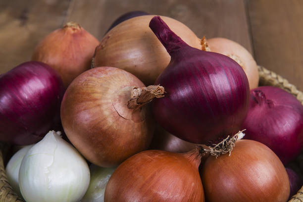 istock Yellow,white and red onion on wooden background. 1089755370
