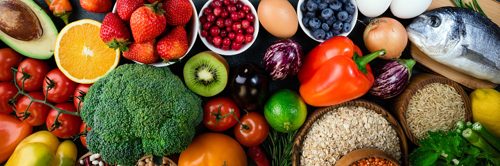 Background healthy food. Fresh fruits, vegetables, fish, berries and cereals. Healthy food, diet and healthy life concept. Top view. Long web format