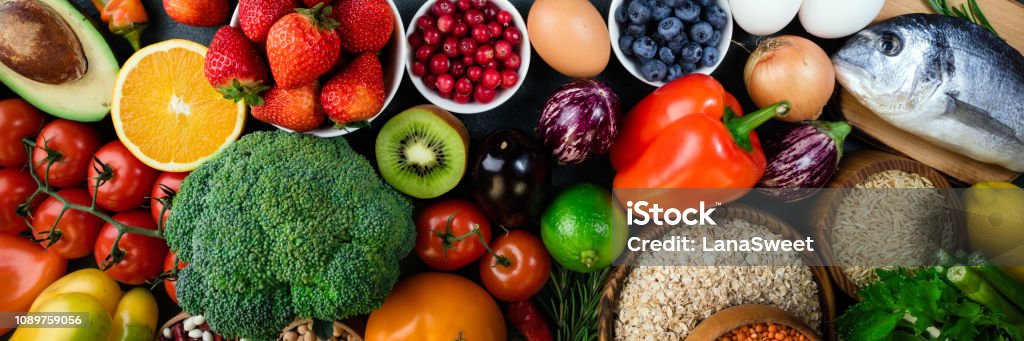 Background healthy food. Fresh fruits, vegetables, fish, berries and cereals. Healthy food, diet and healthy life concept. Top view Background healthy food. Fresh fruits, vegetables, fish, berries and cereals. Healthy food, diet and healthy life concept. Top view. Long web format Fruit Stock Photo