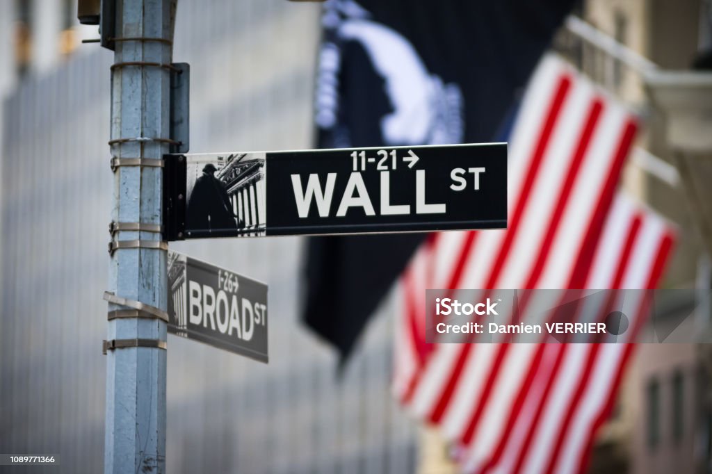 Wall street sign with American flag in the Financial District of Lower Manhattan New York Stock Exchange Stock Photo