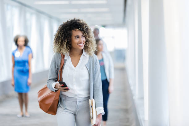 istock Businesswoman walks through hallway with clipboard 1089792530