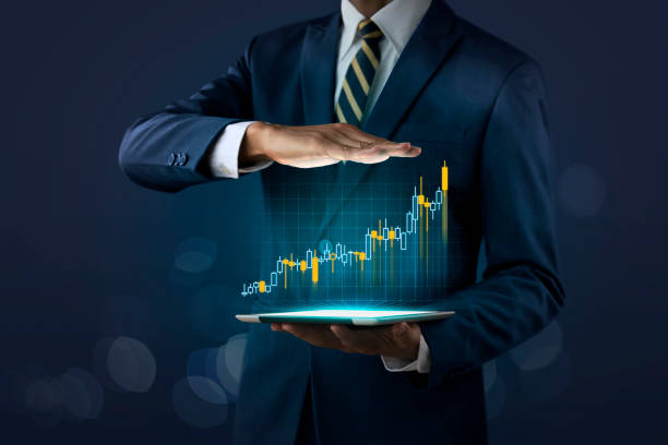 Business growth, progress or success concept. Businessman is showing a growing virtual hologram stock on dark tone background. stock photo