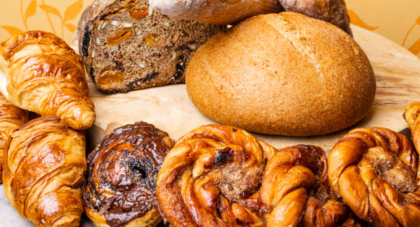 istock Several types of fresh bread, buns lying on wooden board 1089798240