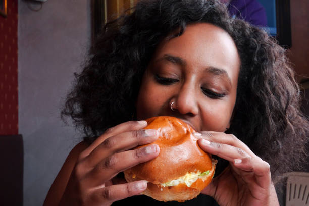 istock Black girl eating a sandwich 1089800304