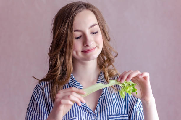 istock Beautiful girl eating celery 1089800480