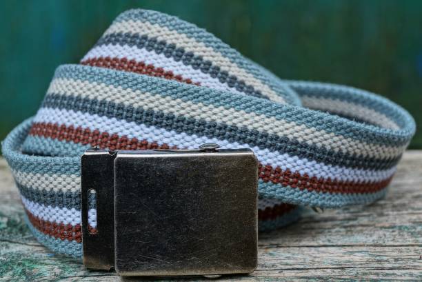 istock striped belt with an iron brown buckle lies on a gray table 1089801834