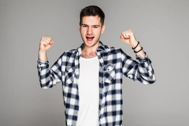 istock Happy winner. Happy young handsome man gesturing and keeping mouth open while standing against white background 1089801870
