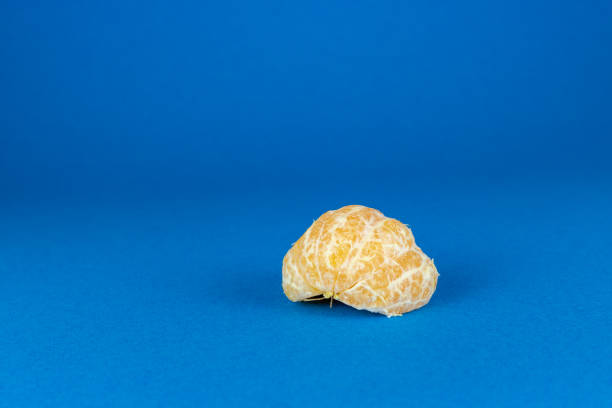 istock Fresh peeled mandarin orange isolated on blue background 1089804180