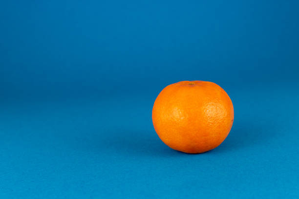 istock Fresh peeled mandarin orange isolated on blue background 1089804268