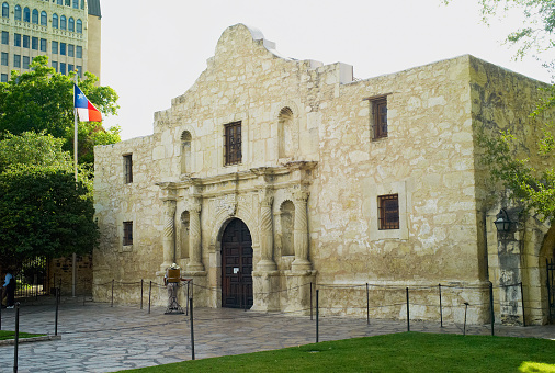 San Antonio, Texas, USA - July 15, 2009: The front facade of The Alamo fort in San Antonio, Texas with a Texan flag.